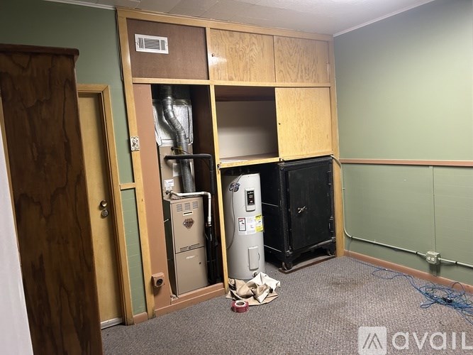 A room with a wood door and a wall-mounted electrical panel.