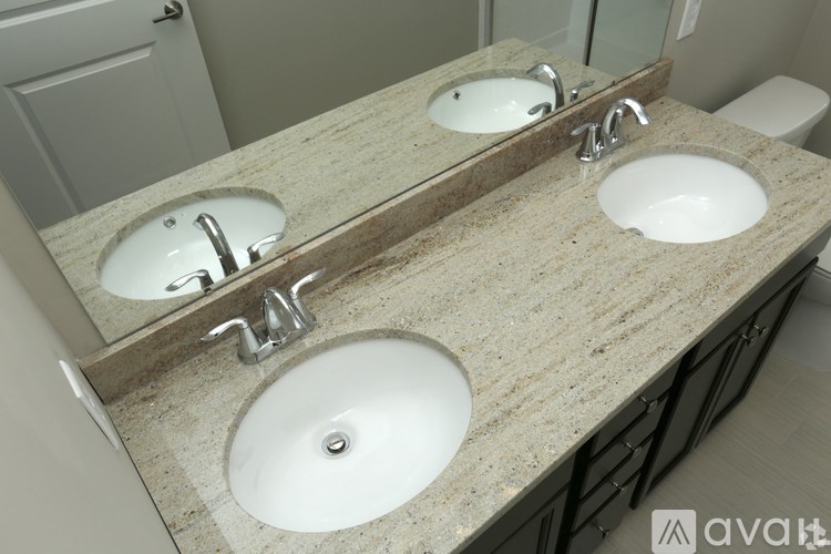 A bathroom with two sinks and a mirror.