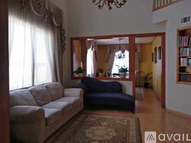 A living room with a couch, a chair, and a rug.