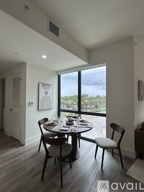 A dining room with a table set for two and a view of the outside.