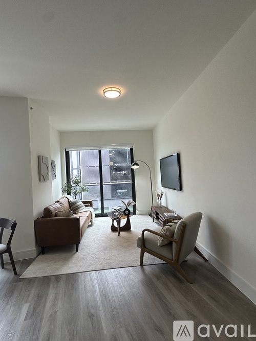 A living room with a couch, chair, and television.