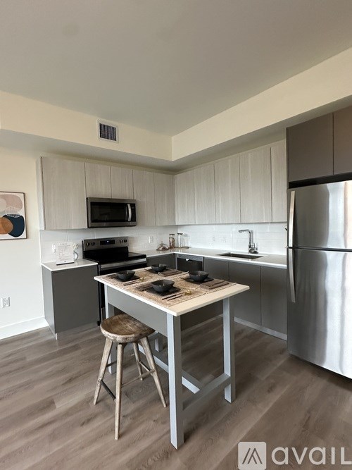 A kitchen with a table and a refrigerator.