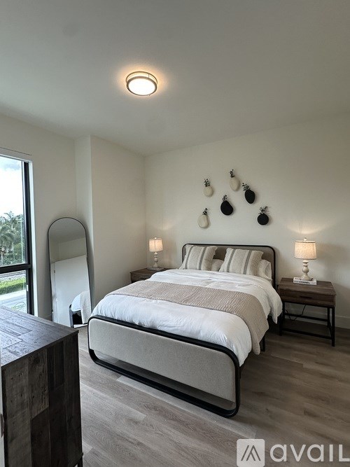 A bedroom with a large bed and a wooden nightstand.