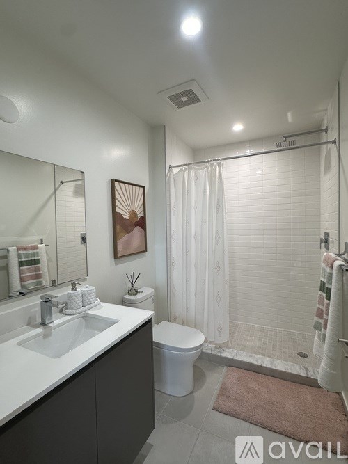 A bathroom with a white sink, toilet, and shower curtain.