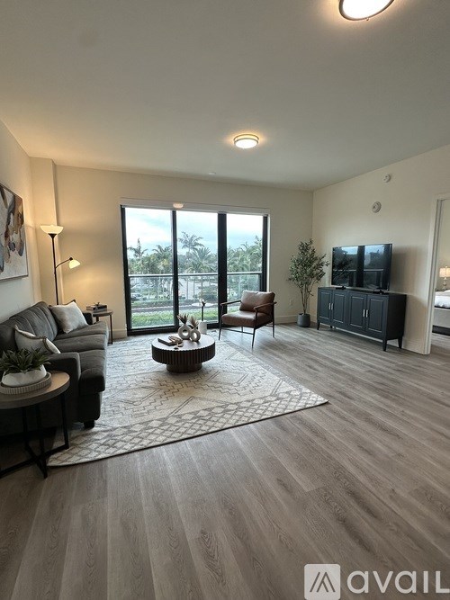 A living room with a grey couch, a coffee table, and a flat screen TV.