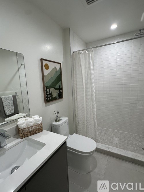 A bathroom with a toilet, sink, and shower.