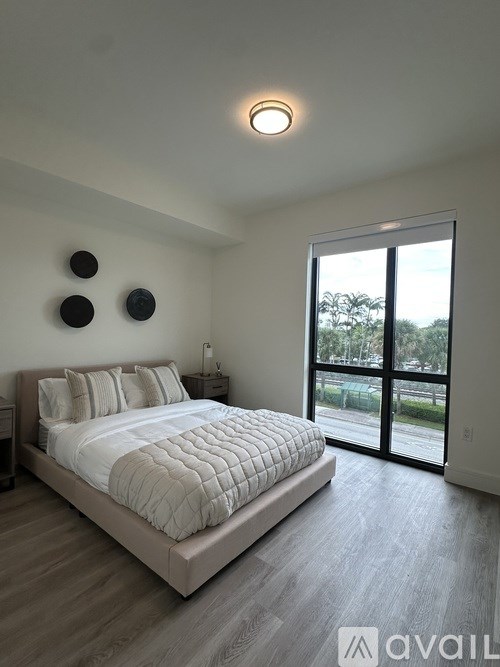 A bedroom with a large bed and a sliding glass door.