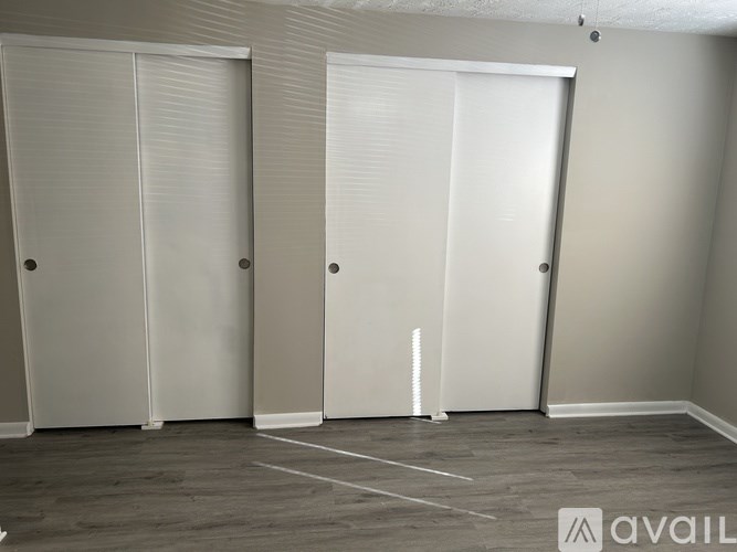 Three white closet doors in a room.
