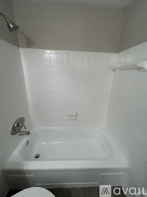 A white bathroom with a white tub and a white toilet.