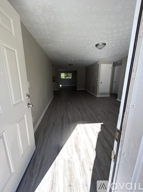 A hallway with white doors and a wooden floor.
