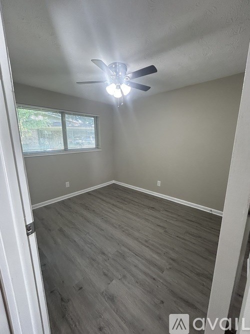 A room with a ceiling fan and a window.