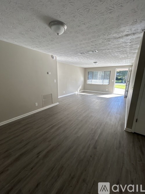A room with wooden flooring and a window.