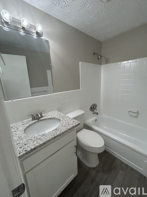 A bathroom with a sink, toilet, and bathtub.