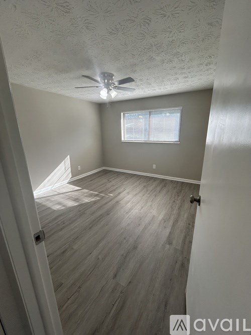 A room with a ceiling fan and a window.