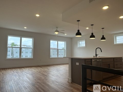A kitchen area with a sink, a window, and a fan.