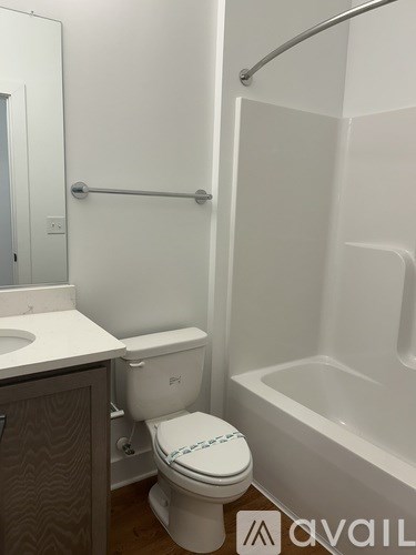 A white toilet with a blue and white towel in a white bathroom.