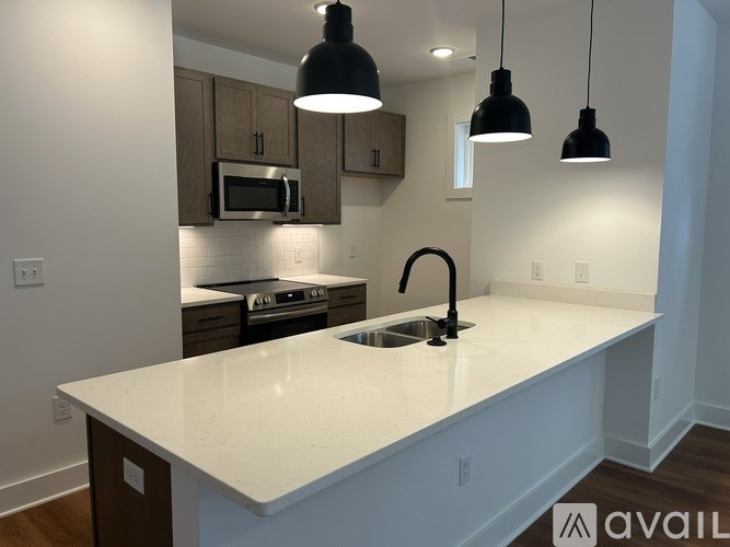 A kitchen with a white countertop and brown cabinets.