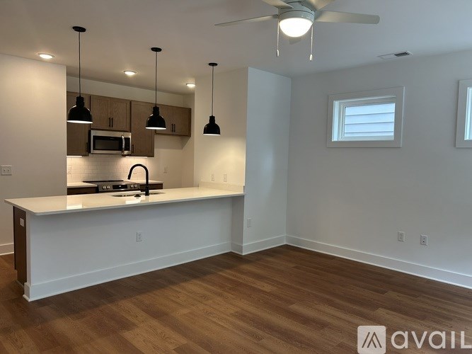 A kitchen with a white countertop and a ceiling fan.