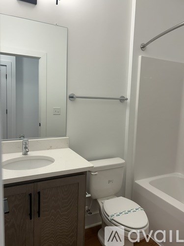 A white toilet with a white sink and a white bathtub in a bathroom.