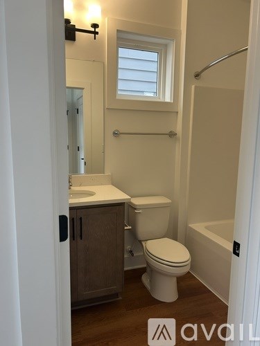 A bathroom with a toilet, sink, and tub.