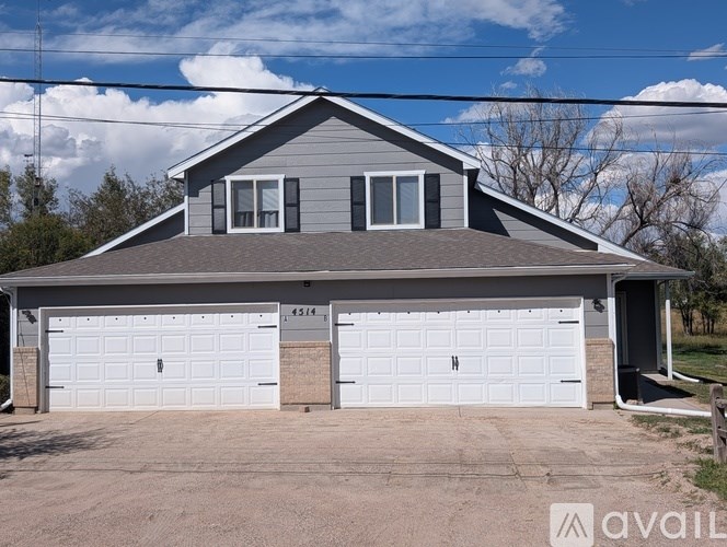 A two-car garage with a grey house in the background.