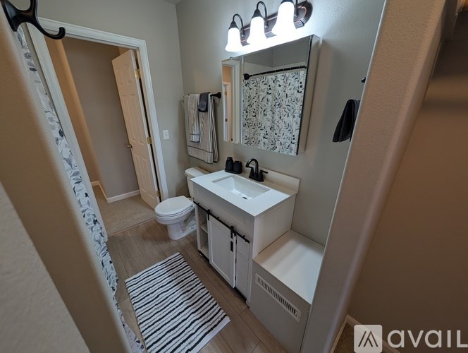 A bathroom with a toilet, sink, and mirror.