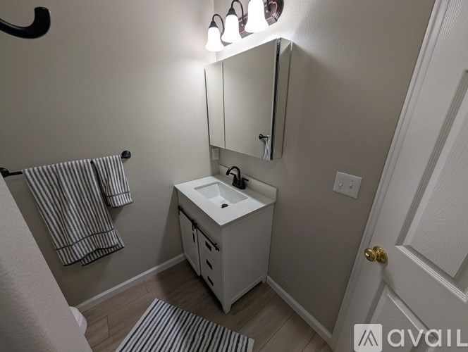 A bathroom with a white sink and a mirror above it.