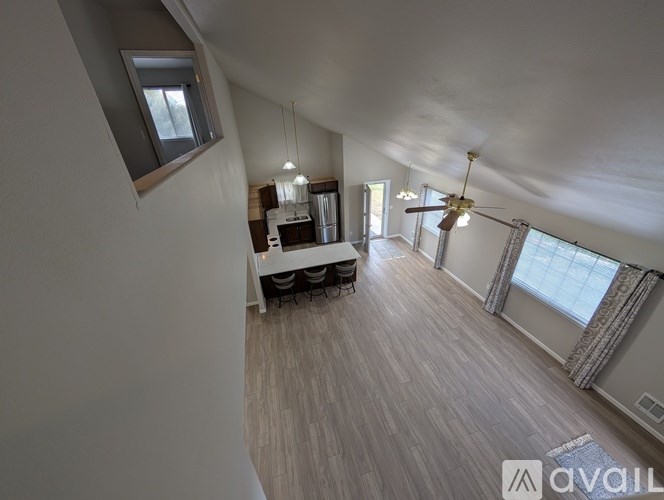 A spacious living room with a kitchen area in the background.