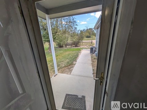 A spacious living room with a kitchen area in the background.