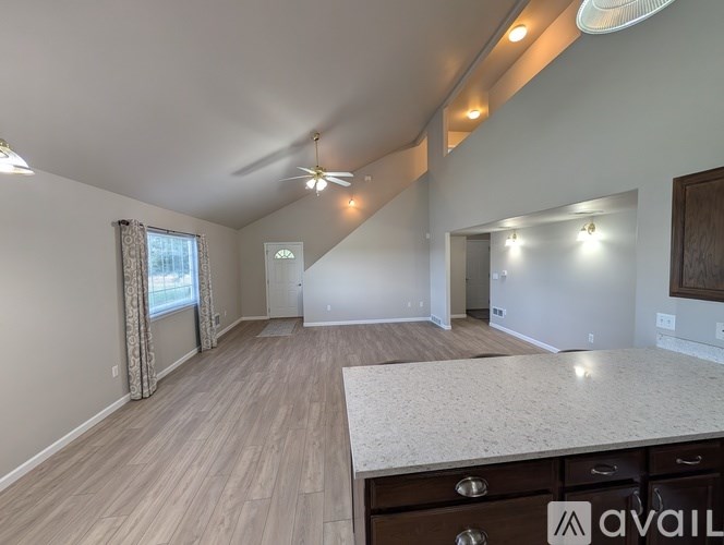 A spacious room with a ceiling fan and lighting fixtures.
