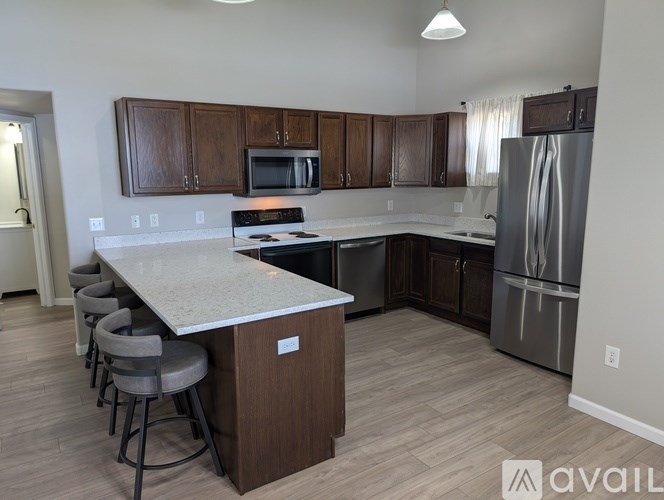 A kitchen with a white countertop and wooden cabinets.
