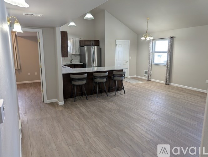 A spacious room with a dining table and chairs.