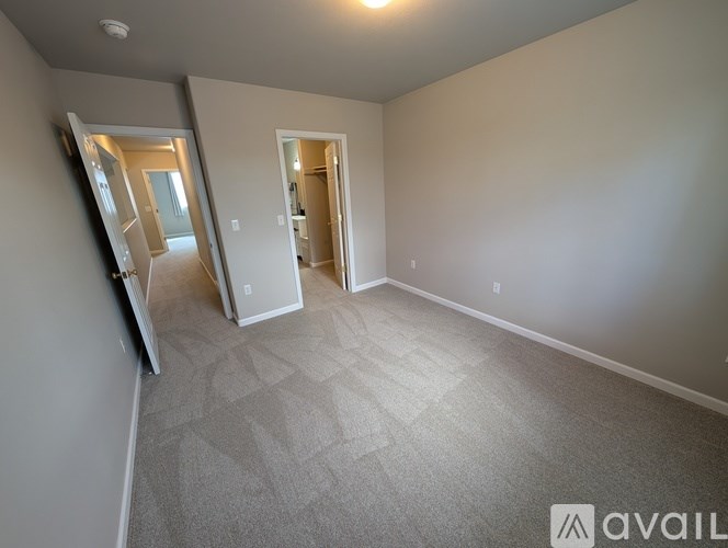 A spacious room with a carpeted floor and a large mirror on the wall.