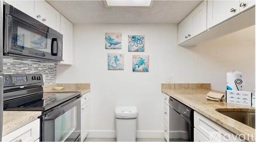 A kitchen with white cabinets and a black stove top oven.