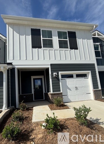 A two-story house with a white garage door and a black front door.
