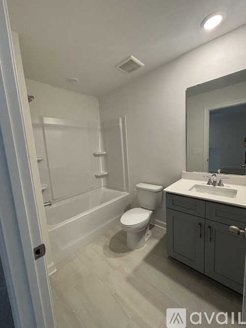 A bathroom with a toilet, sink, and bathtub.