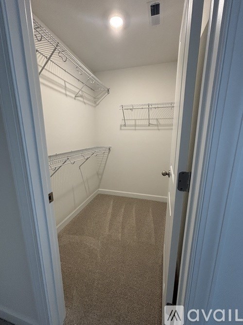 A hallway with a carpeted floor and white walls.