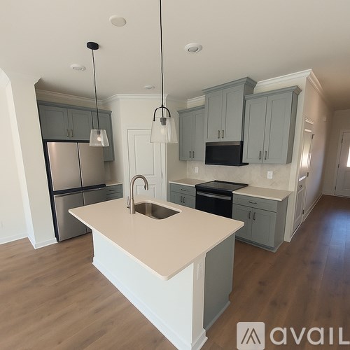 A kitchen with a white island and grey cabinets.
