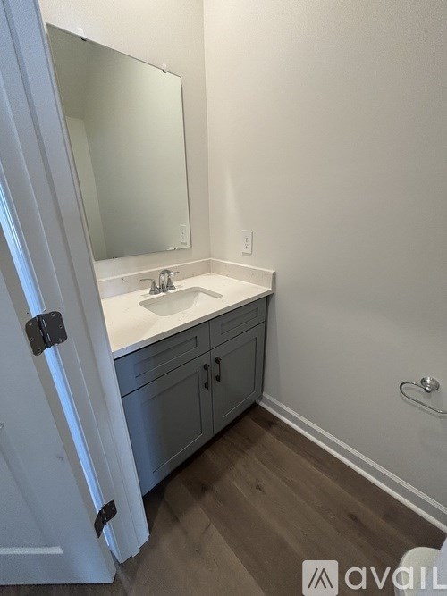 A bathroom with a white sink and a mirror.