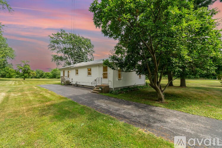 A white house with a tree in front of it.