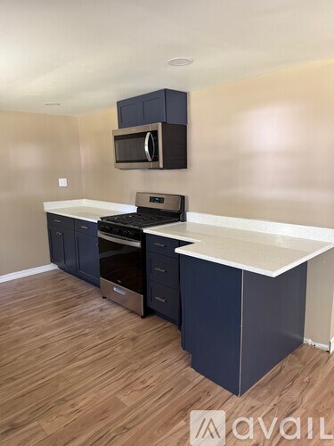 A kitchen with dark blue cabinets and a white countertop.