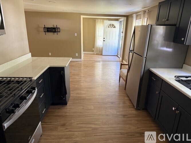 A kitchen with a refrigerator, stove, and cabinets.