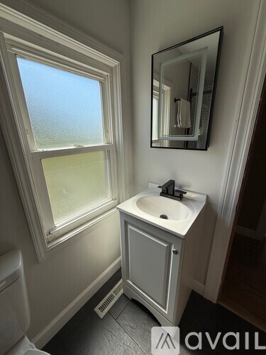 A bathroom with a sink and a window.