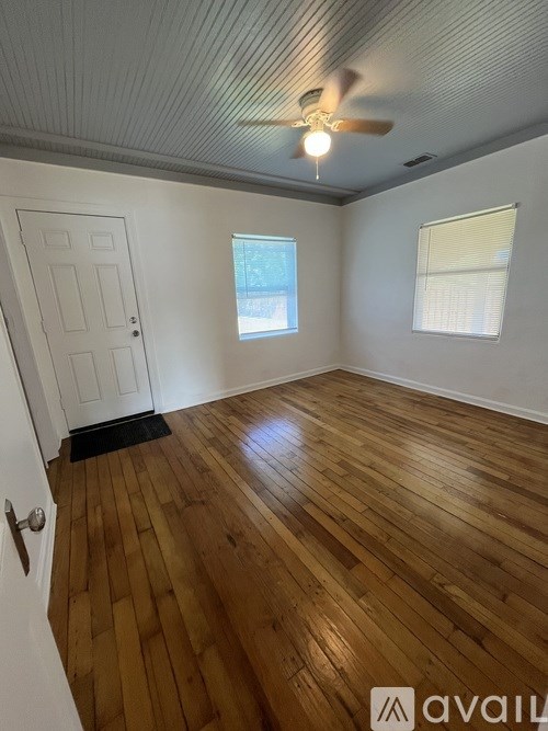 A room with wooden flooring and a ceiling fan.