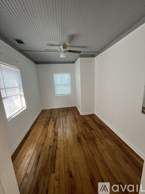 A room with wooden floors and a ceiling fan.