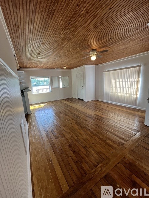 A room with wooden floors and a ceiling fan.