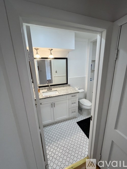 A bathroom with a white tile floor and a white cabinet.