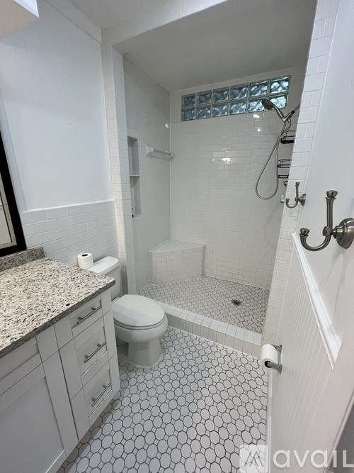 A bathroom with a toilet, sink, and shower.