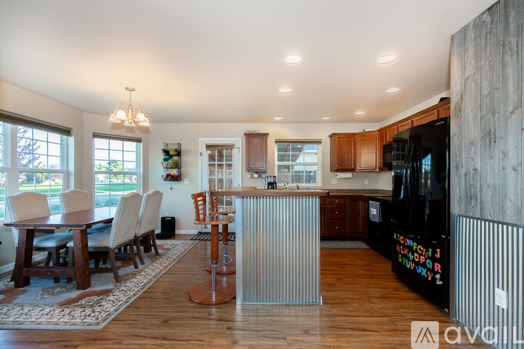 A modern kitchen with wooden floors and a dining table with chairs.