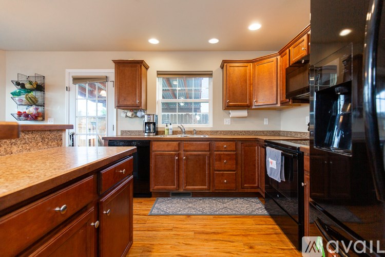 A kitchen with wooden cabinets and a granite countertop.